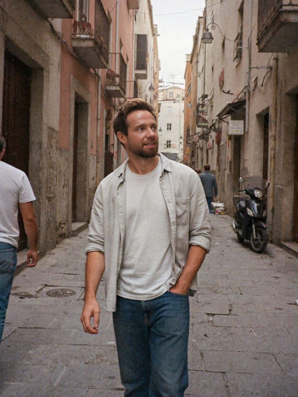 Roman walking down a narrow old-town street